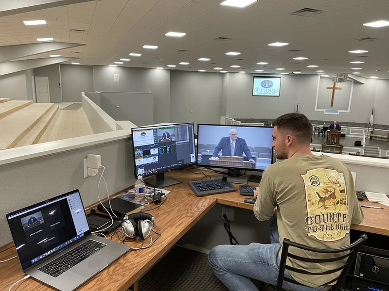 Gethsemane Bible Institute summer-class production position overlooking the church auditorium with an operator monitoring a Zoom conference