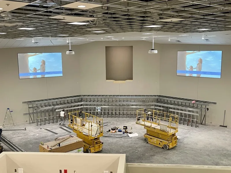 Maple Springs auditorium under construction with two projection systems installed and the ceiling still open