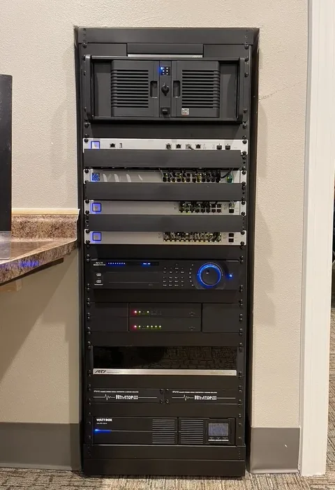 Recessed Maple Springs video and network equipment rack with switching, distribution, control, recording, and backup power